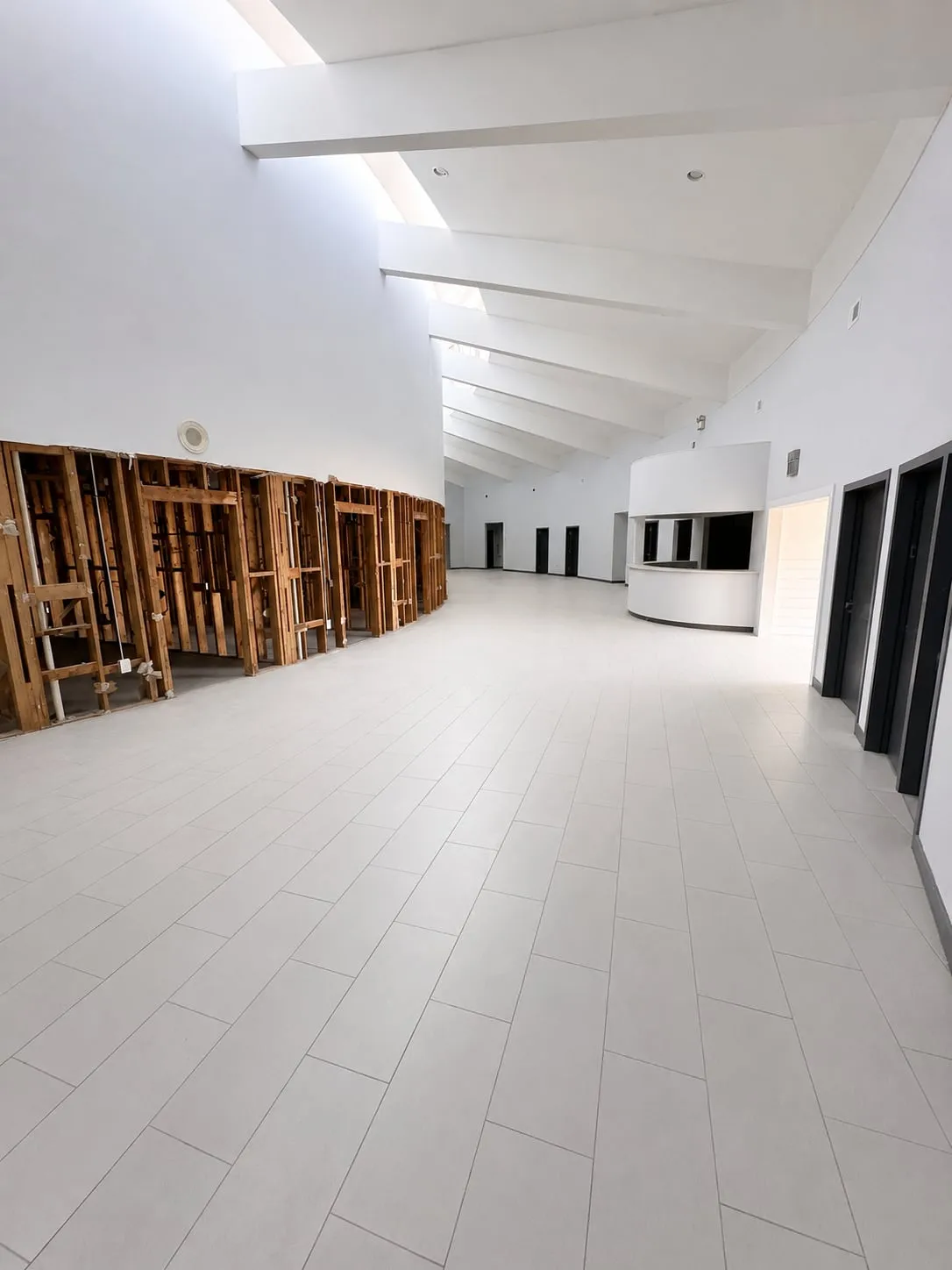 Central atrium of 125 Dillon Drive with vaulted ceiling, clerestory windows, and radial beams; some interior walls opened to wood studs during renovation